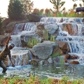 This frontal view of the left half of the main entry waterfall has very strong visual action provided by the water flow of 3,000 gpm over each 12- foot waterfall weir. The oversized fly fisherman and several deer placed throughout this waterfall display enhance the visual aesthetics.