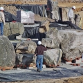 Construction of four large waterfall features is taking place above, with the larger boulders being set first. One thousand tons of select boulders were shipped from New York to Florida for this effort. These boulders sit on a fiber-reinforced concrete pad poured on top of the pond liner.