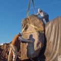 A 10-foot boulder is set in place on one of the four waterfalls. A piece of 2-inch thick styrofoam board sits between the liner and rock during installation to prevent liner damage. This rock will sit on a fiber-reinforced pad, which then allows concrete shims to be used for alignment purposes.