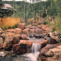 The stepped weir waterfall at right in Silverthorne, Colorado, is built into a live stream at 12,000 feet and is designed to handle varying flows of water developing from melting snow. When water flows increase during warmer weather, the waterfalls seen here increase in size and character, and new waterfalls may form nearby.