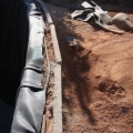 A liner edges, trimmed and secured to a rebar ring inside the block edge.
