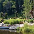 This main pond is heavily planted with aquatics on the shoreline opposite the house. Near the house there is an expansive and soft sandy beach with a boat, fire pit, picnic tables, chairs and floating dock.