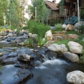 A 450-foot-long cascading and meandering stream was built on the back side of the home. This stream initiates high up on the mountainside, in view of the house, then flows under the driveway and alongside the house, eventually returning to the main pond. This photo shows the stream where it emerges from under the driveway.