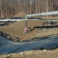 The “bank run” gets installed on top of the pond liner. This material will ultimately be compacted, providing a solid base to walk on and appear as the bottom of a clean streambed.