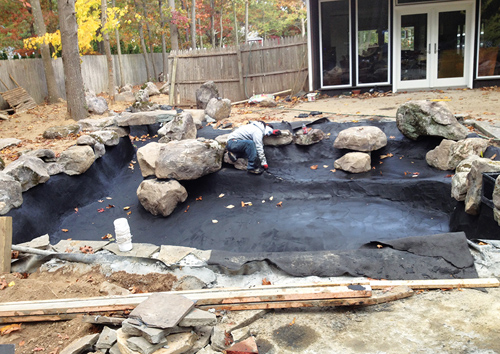 Putting the finishing touches on a black-colored concrete liner.